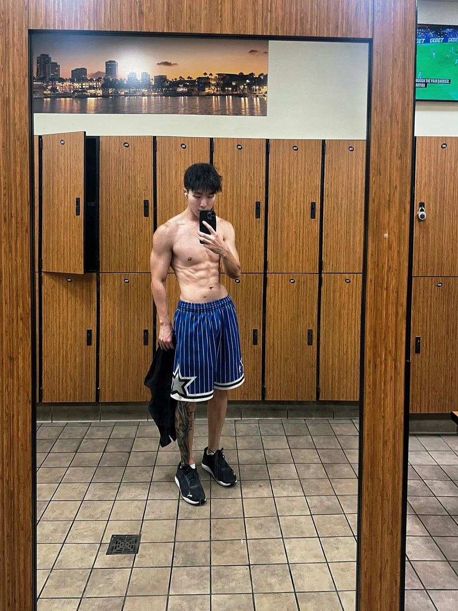 Alan 在更衣室穿蓝色篮球短裤的训练照片